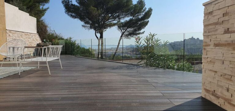 Terrasse en bois bordée d’un garde-corps en verre